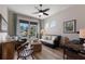 Cozy living area featuring a ceiling fan, large window, hardwood floors, and comfortable seating for a relaxed ambiance at 8227 37Th Avenue W Cir, Bradenton, FL 34209