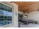 Relaxing covered patio with wood ceiling, ceiling fan, wicker furniture and view of the pool at 8227 37Th Avenue W Cir, Bradenton, FL 34209