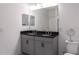 Bathroom featuring double sinks with a black countertop and grey cabinets at 8521 Canyon Creek Trl, Parrish, FL 34219