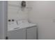 Bright laundry room featuring washer and dryer with shelving above and wall outlets at 8521 Canyon Creek Trl, Parrish, FL 34219