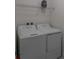 Laundry room with appliances, upper shelving, and 'Laundry Deluxe Service' container at 8521 Canyon Creek Trl, Parrish, FL 34219