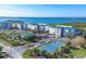 Stunning aerial view of condo community with manicured grounds, tennis courts, and waterfront location with scenic views at 9203 Griggs Rd # A302, Englewood, FL 34224