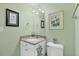 Bathroom featuring green walls, artwork, and a sink with granite countertops at 9203 Griggs Rd # A302, Englewood, FL 34224