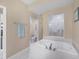 Bathroom featuring a soaking tub, shower, and white tiled floors at 9203 Griggs Rd # A302, Englewood, FL 34224