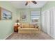 Comfortable bedroom featuring a cozy couch, soft lighting, and a closet for storage at 9203 Griggs Rd # A302, Englewood, FL 34224