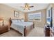 Bright bedroom with a ceiling fan, large window, and wood furniture at 9203 Griggs Rd # A302, Englewood, FL 34224