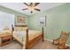 Bedroom featuring green walls, a ceiling fan, and a rocking chair at 9203 Griggs Rd # A302, Englewood, FL 34224