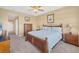 Spacious bedroom with a ceiling fan, light carpet, and wood furniture at 9203 Griggs Rd # A302, Englewood, FL 34224