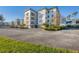 Multi-story condo building with manicured landscaping, ample parking, and a well-maintained facade at 9203 Griggs Rd # A302, Englewood, FL 34224
