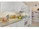Well-equipped kitchen featuring stainless appliances, granite countertops, white cabinetry and a large pantry for ample storage at 9203 Griggs Rd # A302, Englewood, FL 34224