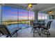 Screened lanai showcases water views with a ceiling fan, tiled floors, and a dining set for outdoor enjoyment at 9203 Griggs Rd # A302, Englewood, FL 34224