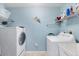 Well-equipped laundry room with modern washer and dryer, along with ample shelving at 9203 Griggs Rd # A302, Englewood, FL 34224