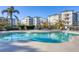 Inviting community pool surrounded by lush landscaping and comfortable lounge seating at 9203 Griggs Rd # A302, Englewood, FL 34224
