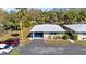 An aerial view of the property with a gray roof, carport, and verdant landscaping highlighting curb appeal at 94 Strathmore Blvd, Sarasota, FL 34233