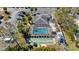 Overhead view of a screened pool, shuffleboard courts, palm trees, and parking lot at a community center at 94 Strathmore Blvd, Sarasota, FL 34233