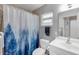Neutral bathroom with a white vanity, toilet, shower-tub combination with a blue and white shower curtain at 94 Strathmore Blvd, Sarasota, FL 34233
