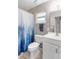 Neutral bathroom with a white vanity, toilet, shower-tub combination with a blue and white shower curtain at 94 Strathmore Blvd, Sarasota, FL 34233