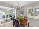 Bright dining area with an elegant chandelier, wooden table set, and a view into the adjacent sunroom at 94 Strathmore Blvd, Sarasota, FL 34233