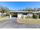 Charming single-story home featuring a covered carport, well-maintained lawn, and classic Florida landscaping at 94 Strathmore Blvd, Sarasota, FL 34233