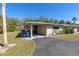 Charming single-story home featuring a carport and well-maintained landscaping under a clear blue sky at 94 Strathmore Blvd, Sarasota, FL 34233