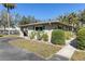 The building's exterior showcases lush landscaping, green shutters, and a well-maintained lawn with a driveway at 94 Strathmore Blvd, Sarasota, FL 34233