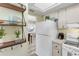 Kitchen area featuring a refrigerator, stove and sink with white cabinets and modern appliances at 94 Strathmore Blvd, Sarasota, FL 34233