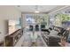 Comfortable living room featuring a plush couch, large windows, and a modern entertainment center with a television at 94 Strathmore Blvd, Sarasota, FL 34233