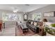 Inviting living room with a large couch, ottoman, and a view of the surrounding greenery at 94 Strathmore Blvd, Sarasota, FL 34233