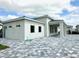 Modern home featuring clean lines and a paved driveway, set under a bright, cloudy sky at 10006 Degas Ter, Bradenton, FL 34212
