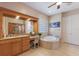 Bathroom featuring a dual sink vanity, a soaking tub, a glass block window, and neutral tile at 1009 3Rd E St, Palmetto, FL 34221