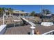 Private boat dock featuring a boat lift, jet ski lift, and seating area at 1009 3Rd E St, Palmetto, FL 34221