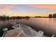 Two white Adirondack chairs face the water from a dock during a bright and vibrant sunset at 1009 3Rd E St, Palmetto, FL 34221