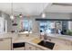 Elegant kitchen with marble countertops, a modern sink, and sliding glass doors leading to the outdoor pool and dock at 1009 3Rd E St, Palmetto, FL 34221