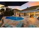 Gorgeous backyard pool with lush tropical landscaping and elegant outdoor furniture at 1009 3Rd E St, Palmetto, FL 34221