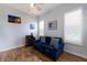 Comfortable sitting room featuring a plush blue sofa, wood floors, and natural light from shuttered windows at 1009 3Rd E St, Palmetto, FL 34221