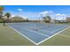 Community tennis and pickleball courts surrounded by tropical landscaping, trees, and docks at 1009 3Rd E St, Palmetto, FL 34221