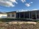 Back exterior of home with screened patio and view of the back yard at 10443 Keystone St, Spring Hill, FL 34608