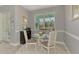 Bright dining area offers a glass-top table, white chairs, and views of the outdoors at 107 Wayforest Dr, Venice, FL 34292