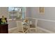 Cozy dining area features a glass-top table, comfortable seating, and natural light from the window at 107 Wayforest Dr, Venice, FL 34292