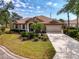 Beautiful single-story home boasting mature landscaping, a tile roof, a two-car garage, and a well-maintained lawn at 107 Wayforest Dr, Venice, FL 34292