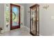 Charming foyer showcasing marble floors, a display cabinet, and a beautiful front door with decorative glass at 107 Wayforest Dr, Venice, FL 34292