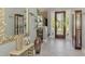 Elegant foyer featuring marble floors, a decorative mirror, a display cabinet, and a beautiful front door with sidelights at 107 Wayforest Dr, Venice, FL 34292