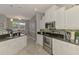 Spacious kitchen with granite countertops, stainless steel appliances, and a seamless flow to the dining area at 107 Wayforest Dr, Venice, FL 34292