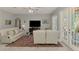 Spacious living room featuring tile flooring, plush seating, and backyard access at 107 Wayforest Dr, Venice, FL 34292