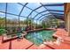 Sparkling screened-in pool area with hot tub, lush landscaping, and ample space for recreation at 107 Wayforest Dr, Venice, FL 34292