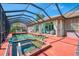 Relaxing screened-in pool and hot tub area with patio access, seating, and lush tropical plants at 107 Wayforest Dr, Venice, FL 34292