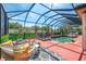 Inviting screened-in pool area featuring a hot tub, lounge seating, and lush landscaping at 107 Wayforest Dr, Venice, FL 34292
