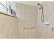 Tiled shower featuring a shower head, grab bar and built in alcove shelves at 107 Wayforest Dr, Venice, FL 34292