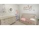 Serene Bedroom with light gray walls, wood furniture, and crib with pink accents at 11111 Encanto Ter, Bradenton, FL 34211