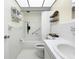 Well-lit bathroom featuring a tiled shower-tub combo, white fixtures, and hexagon tile flooring at 11251 80Th Ave # 305, Seminole, FL 33772